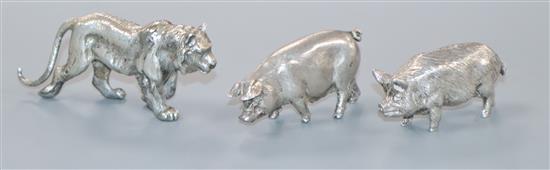 Two modern silver miniature models of pigs and a white metal lion.